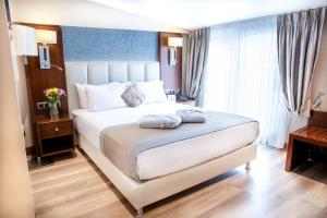 Postel nebo postele na pokoji v ubytování Grand Aras Hotel & Suites