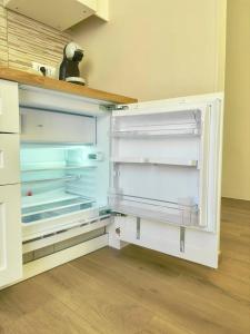 an empty refrigerator with its doors open in a kitchen at Casa Luciana Apartment in San Giovanni Rotondo