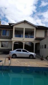 une voiture en argent garée devant une maison dans l'établissement Twiga Whitehouse Villas, à Nakuru