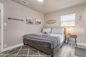 a bedroom with a bed with a nightstand and a window at Amazing Hot tub l Sleeps 14 in Amarillo