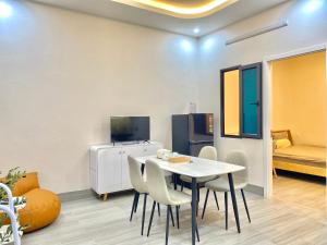 a dining room with a white table and chairs at G-space apartment in Hai Phong