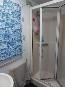 een badkamer met een douche en een glazen deur bij Three Peaks View. in Clitheroe