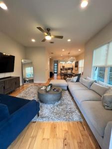 a living room with a blue couch and a tv at Beautiful New Home Downtown SXSW ACL F1 HQ in Austin