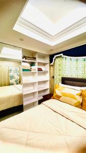a bedroom with two beds and a skylight at Cozy 54 sqm one bedroom unit with 400 mbps WI-FI and sunset skyline view in Manila