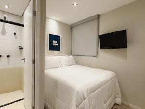 a small bedroom with a bed and a flat screen tv at Apê Metrô Paulista in Sao Paulo