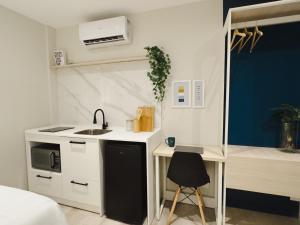 eine kleine Küche mit einem Waschbecken und einem Schreibtisch in der Unterkunft Apê Metrô Paulista in São Paulo