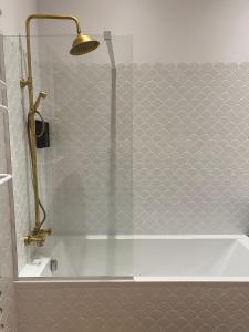 Łazienka z prysznicem i wanną ze szklanymi drzwiami w obiekcie Apartments PSD - Anny Łajming 1B w mieście Słupsk