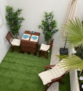 une terrasse avec une table, des chaises et des plantes dans l'établissement Apartamento 315 Castell Sol CB, à Arenal d'en Castell