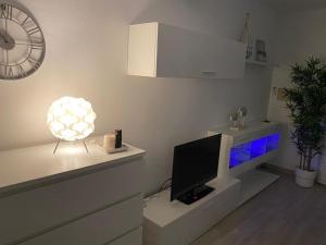 - un salon avec une télévision et une horloge murale dans l'établissement Apartamento 315 Castell Sol CB, à Arenal d'en Castell