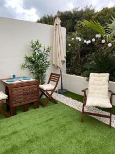 - une terrasse avec 2 chaises, un bureau et un parasol dans l'établissement Apartamento 315 Castell Sol CB, à Arenal d'en Castell