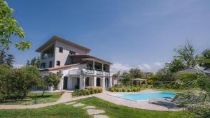 a house with a swimming pool in front of it at Electra BeachFront Suites, Nea Irakleia in Nea Irakleia