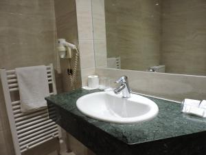 uma casa de banho com um lavatório e um espelho em Hotel El Nogal em Valladolid