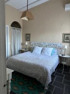 a bedroom with a bed and two tables with lamps at La Casita de Teresa in Córdoba