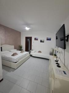a hotel room with two beds and a flat screen tv at Casa Amelia lago Maggiore in Maccagno Inferiore