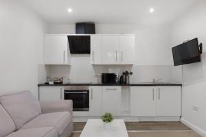 a living room with white cabinets and a couch at Central and Modern One Bedroom Flat 201 in Oxford