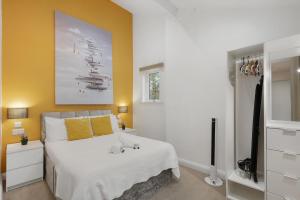 a bedroom with a white bed with yellow walls at Central and Modern One Bedroom Flat 201 in Oxford