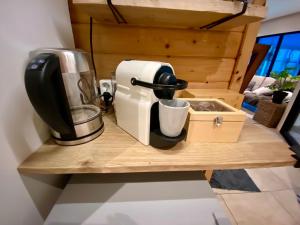 een koffiezetapparaat op een houten aanrecht met koffiezetapparaat bij B&B Wellness Soest in Soest