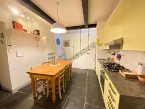 een grote keuken met een houten tafel en een aanrecht bij CHIAVE DI VOLTA Lovely Guesthouse with Terrace in Varenna