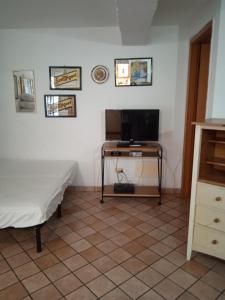 una camera con un letto e una televisione su un tavolo di Dea's House con parcheggio a Gaeta