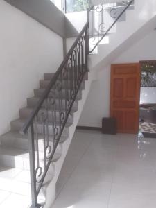 a staircase with a metal railing next to a door at Augustin Guest House in Point Pedro