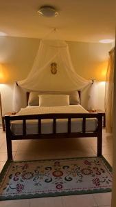 Manousos Guest House في مدينة هيراكيلون: سرير مع مظلة في الغرفة
