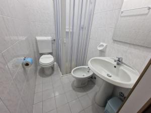 La salle de bains blanche est pourvue de toilettes et d'un lavabo. dans l'établissement La Locanda di Bivigliano, à Bivigliano