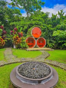 a fountain with three drums sitting in a garden at Arenal Secret Gardens in Fortuna