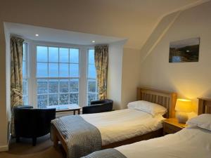 a hotel room with two beds and a window at Hartland Quay Hotel in Hartland