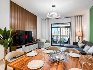 a living room with a table with chairs and a television at Spacious 1br With Swimming Pool in Dubai