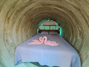 two pink flamingos laying on a bed in a tunnel at Arenal Secret Gardens in Fortuna