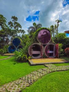 a house with round windows in the grass at Arenal Secret Gardens in Fortuna