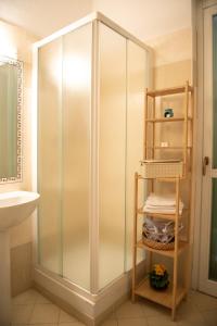 ein Badezimmer mit einer Dusche und einem Regal mit Handtüchern in der Unterkunft APPARTAMENTO ALESSANDRA in Alba