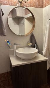 La salle de bains est pourvue d'un lavabo blanc et d'un miroir. dans l'établissement Manousos Guest House, à Héraklion