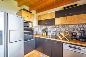 a kitchen with a white refrigerator and a sink at Ty Jane Dour - Maison avec jardin in Plouhinec +7 photos
