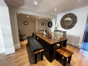 a dining room with a wooden table and a mirror at Malvern House in Deal