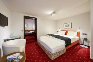 ベルンカステル・クースにあるホテル ツル ポストのベッドとテーブルが備わるホテルルームです。