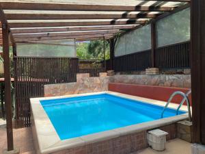a swimming pool with a wooden pergola and a swimming pool at Michelangelo's House in Gioiosa Marea