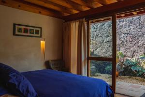 1 dormitorio con cama y ventana grande en La Hacienda Tepoztlán Awarded - Firenze Entremuros, en Tepoztlán