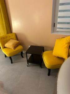 two yellow chairs and a table in a room at Crownn - Spa Privatif in Fontenay-sous-Bois