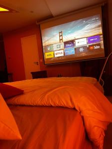 a bedroom with a large screen on the wall at Crownn - Spa Privatif in Fontenay-sous-Bois