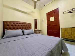 - une chambre avec un lit et une porte rouge dans l'établissement Teratak Tok Ma Rumah Cengal, à Kuala Terengganu
