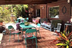 eine Terrasse mit Stühlen, einem Tisch und einer Bank in der Unterkunft Hermosa, arbolada y amplia in La Floresta