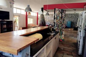 uma cozinha com um balcão de madeira e um lavatório em Hermosa, arbolada y amplia em La Floresta
