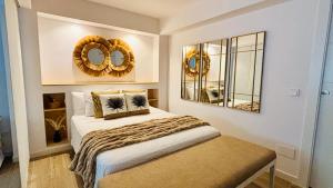 a bedroom with a bed and two mirrors on the wall at EL PISITO SAND, a 700 metros del casco antiguo in Marbella