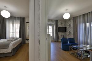 a bedroom with a bed and blue chairs and a table at Como Lake Suites in Como +93 photos