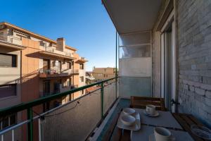 uma varanda com uma mesa e cadeiras num edifício em [Elegante e Moderno Appartamento]-Colin Home em Sanremo