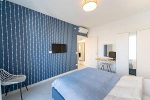 a bedroom with a bed and a tv on a wall at [Elegante e Moderno Appartamento]-Colin Home in Sanremo