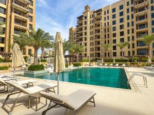 a swimming pool with lounge chairs and umbrellas at Spacious 1br With Swimming Pool in Dubai