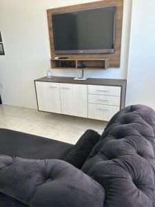 a living room with a flat screen tv and a couch at Loft Central in Passo Fundo