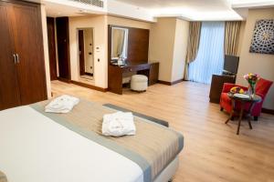 Postel nebo postele na pokoji v ubytování Grand Aras Hotel & Suites